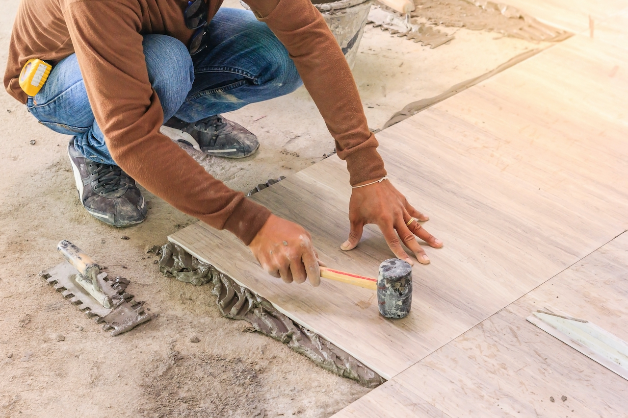 Home improvement, renovation - construction worker tiler is tiling, ceramic tile floor adhesive