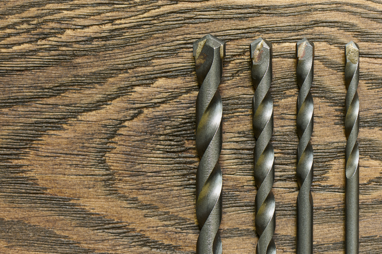 Set of drill bits on a wooden table, close up